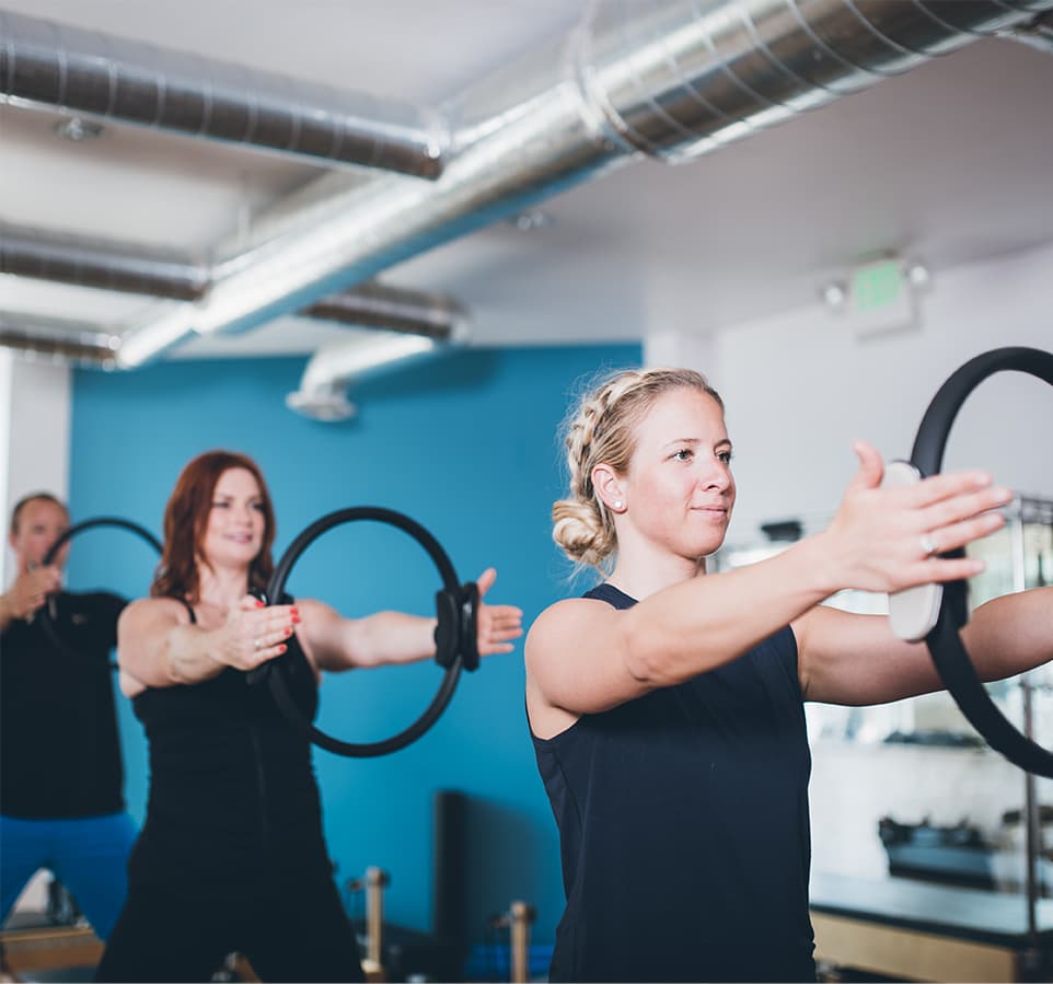 Three clients standing on the main floor pressing magic circles overhead